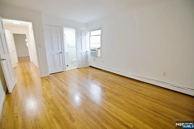 a view of a room with wooden floor and bathroom