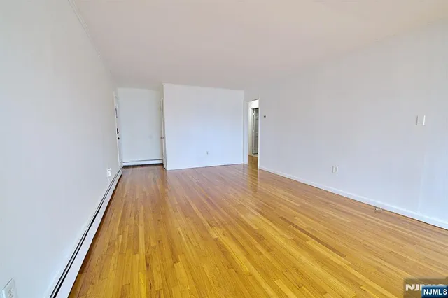 a view of a room with wooden floor and bench