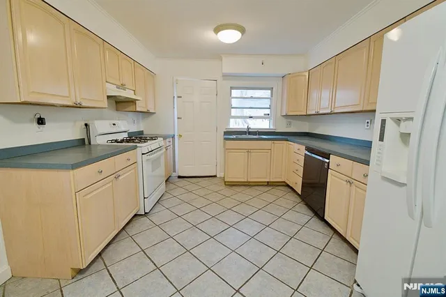 a kitchen with white cabinets stainless steel appliances and a sink