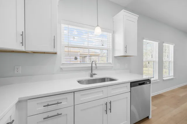 a kitchen with cabinets appliances a sink and a window