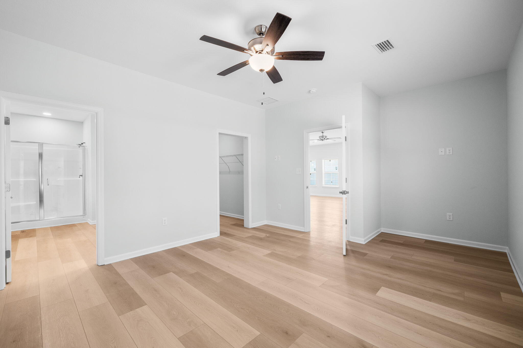 72 Riverwalk Circle Freeport, FL 32439 - Photo 13 of 34 a view of an empty room with wooden floor and a ceiling fan