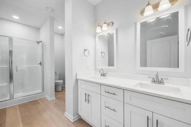 a bathroom with a double vanity sink mirror and shower