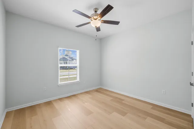 an empty room with a window and a fan
