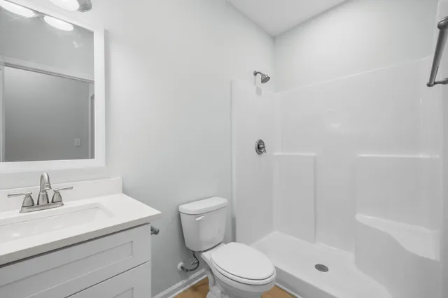 a bathroom with a sink a toilet and shower