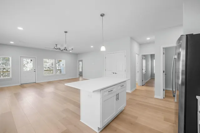 a view of a kitchen island a chandelier and wooden floor