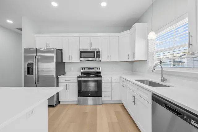 a kitchen with kitchen island granite countertop a sink stainless steel appliances and window
