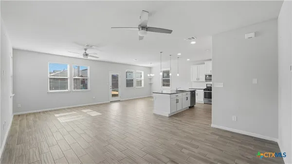 a view of a kitchen with wooden floor and a window