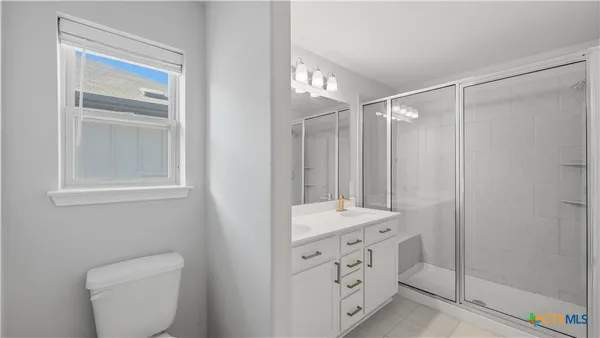 a spacious bathroom with a toilet a sink and mirror