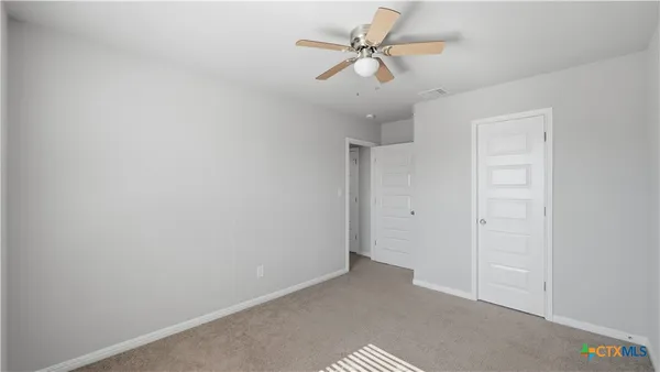 an empty room with a ceiling fan and a window