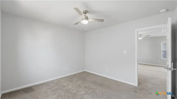 an empty room with closet and ceiling fan