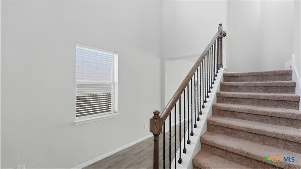 a view of staircase with wooden floor and a window