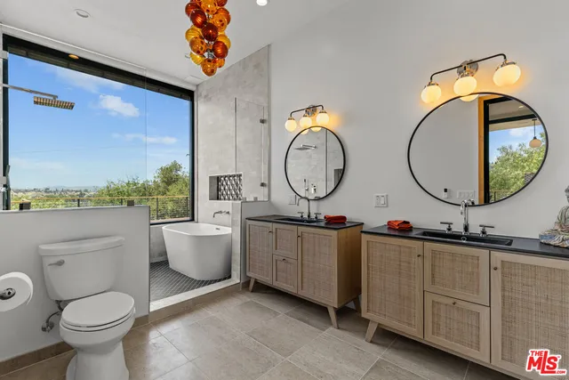 a bathroom with a toilet a sink a mirror and a bathtub