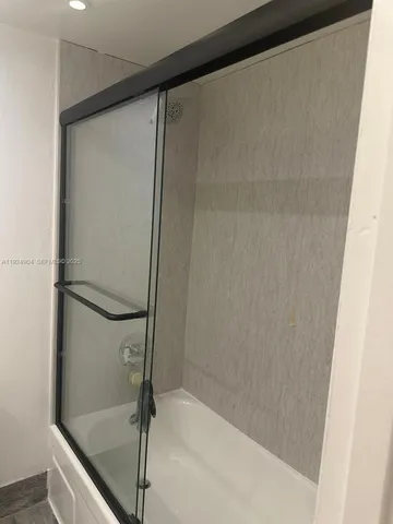 a bathroom with a glass shower door