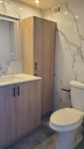 a bathroom with a sink a toilet a mirror and shower