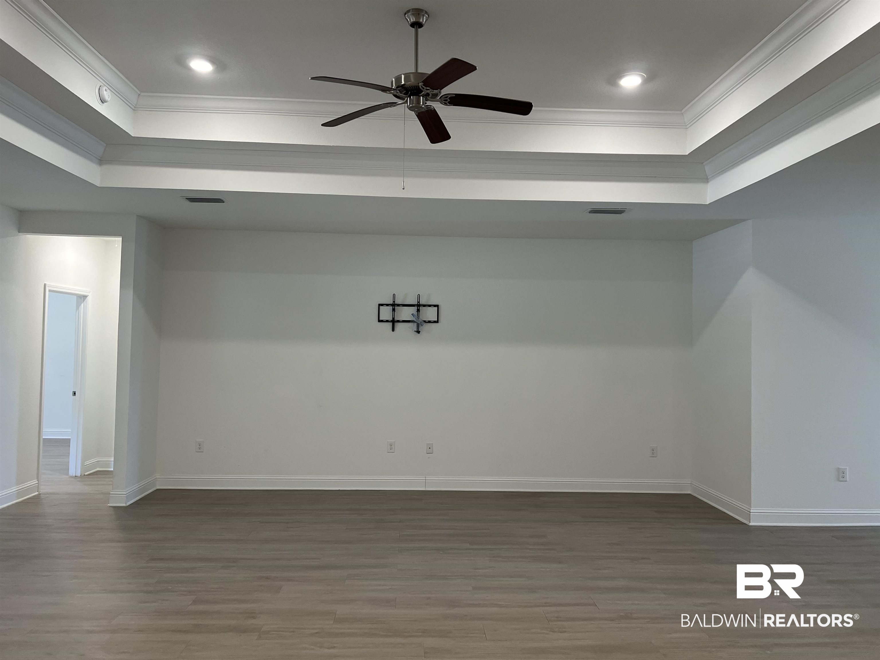 8855 Calverton Street Foley, AL 36535 - Photo 43 of 76 Empty room with a tray ceiling, hardwood / wood-style flooring, ceiling fan, and ornamental molding