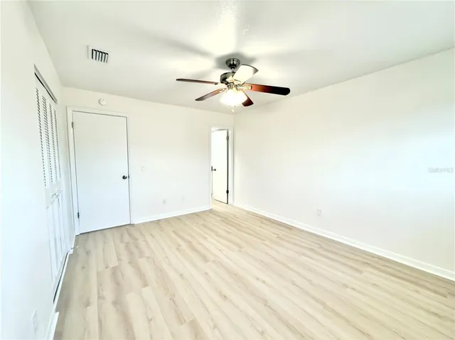 a view of empty room with wooden floor