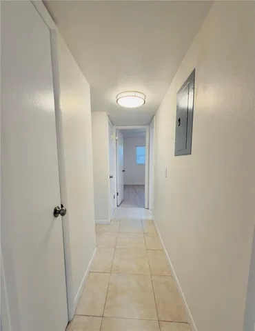 a view of a hallway with wooden floor and a bathroom