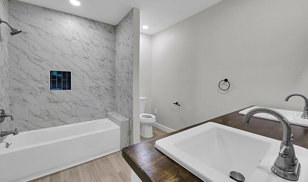 1713 Reuter Avenue Waco, TX 76708 - Photo 16 of 34 Full bathroom featuring a sink, wood finished floors, toilet, recessed lighting, and bathtub / shower combination