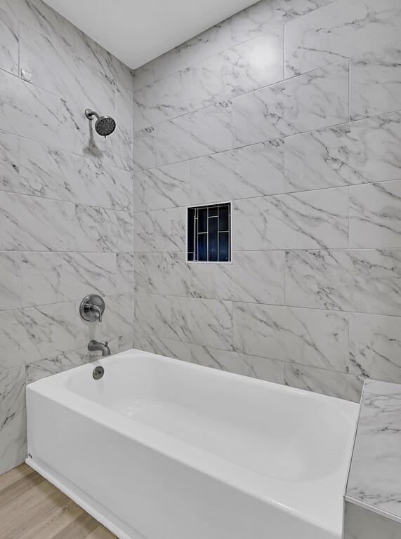 1713 Reuter Avenue Waco, TX 76708 - Photo 18 of 34 Bathroom featuring bathing tub / shower combination and wood finished floors