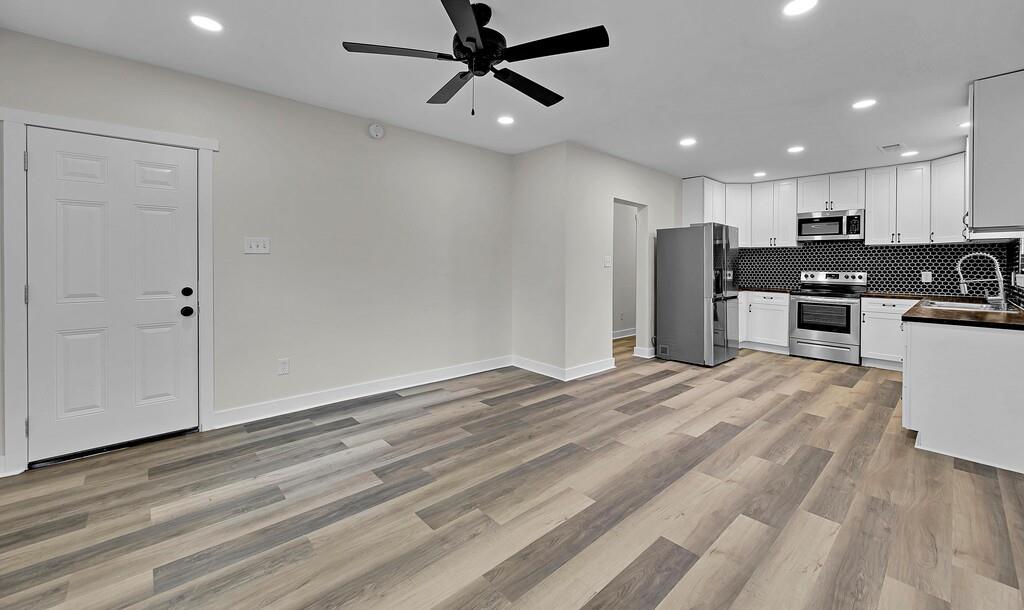 1713 Reuter Avenue Waco, TX 76708 - Photo 5 of 34 Kitchen featuring stainless steel appliances, dark countertops, a ceiling fan, a sink, and recessed lighting