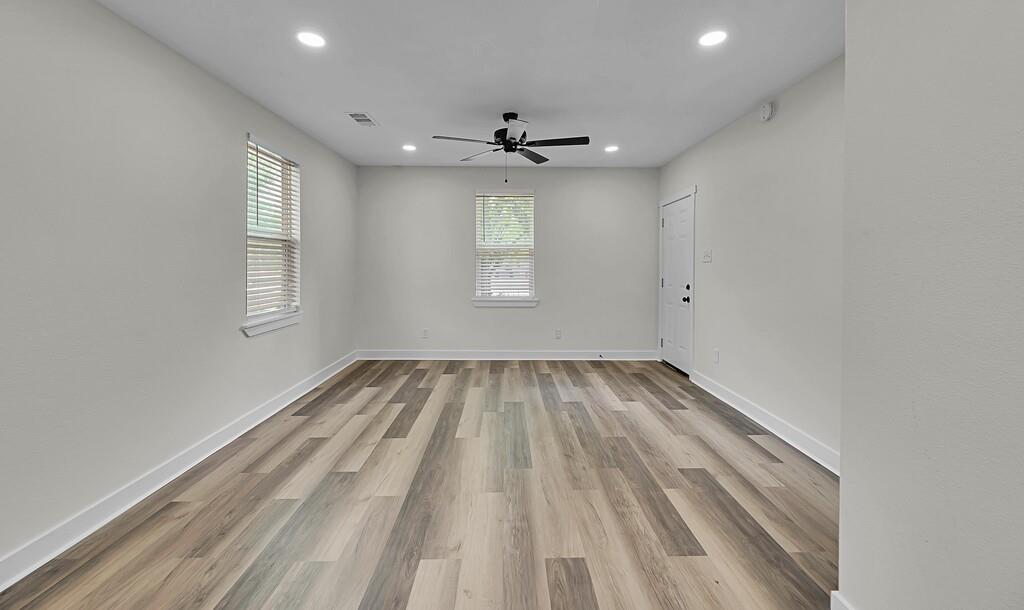 1713 Reuter Avenue Waco, TX 76708 - Photo 6 of 34 Empty room with healthy amount of natural light, a ceiling fan, recessed lighting, wood finished floors, and baseboards