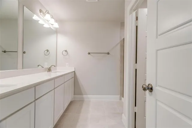 a bathroom with a double vanity sink mirror and shower
