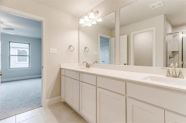 a bathroom with double vanity sink a vanity and a mirror