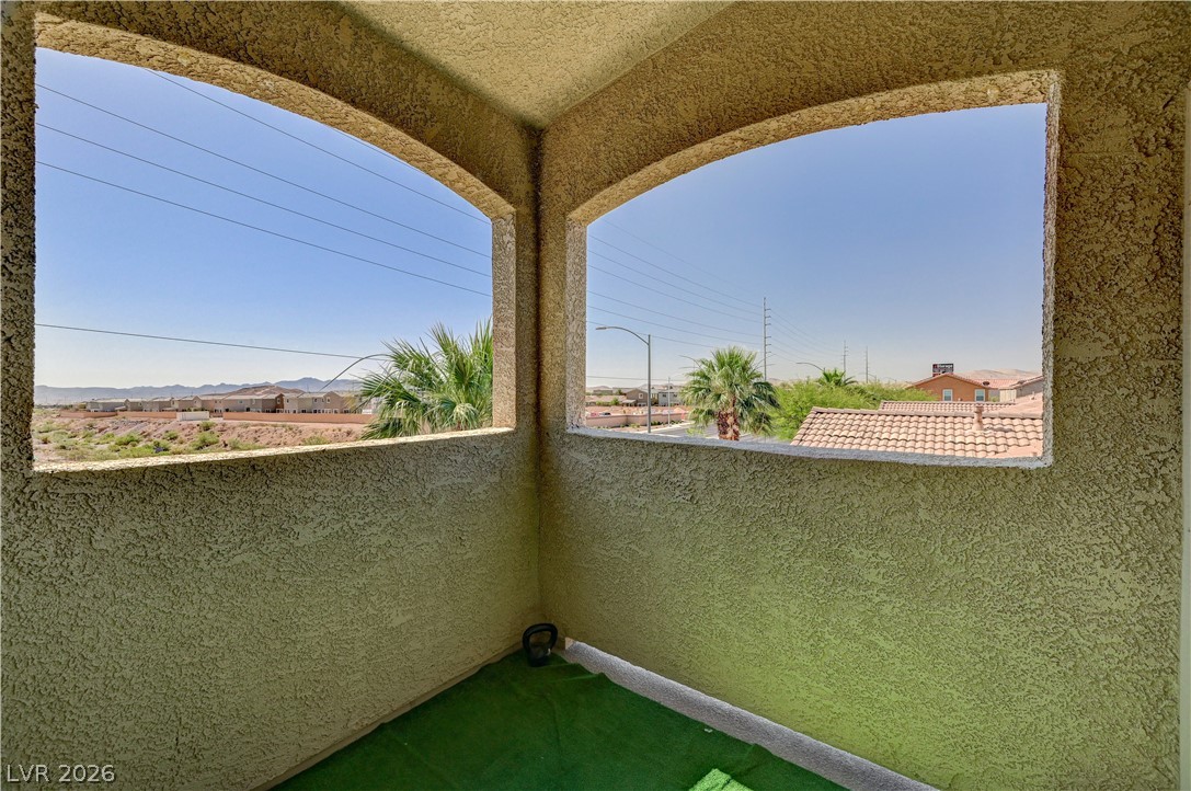8985 South Durango Drive, Unit 2187 Las Vegas, NV 89113 - Photo 20 of 73 Two arched windows frame desert and mountain vistas from a secluded balcony retreat.