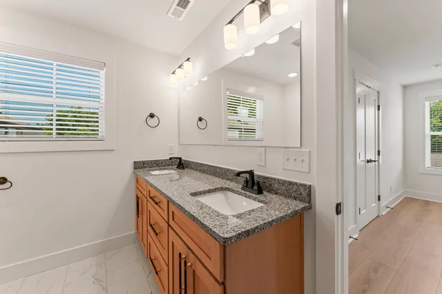 a bathroom with a granite countertop sink and a mirror