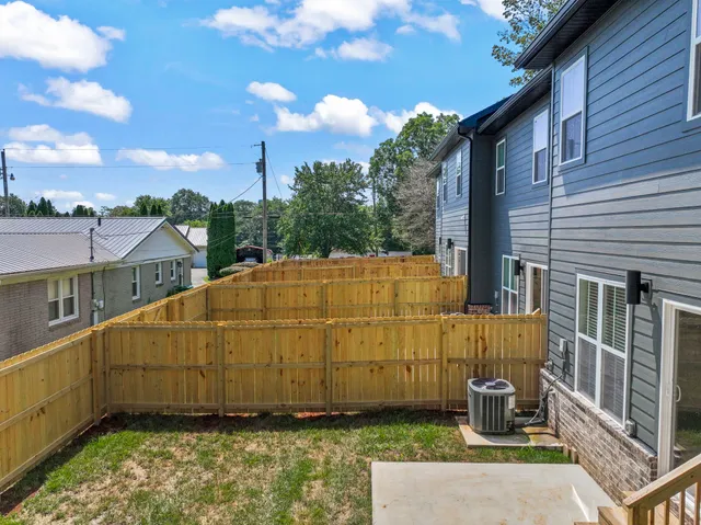 a blue and white house with a small yard and wooden fence