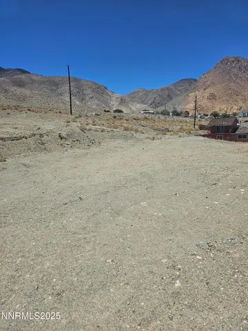 a view of a dry yard with mountain in the background