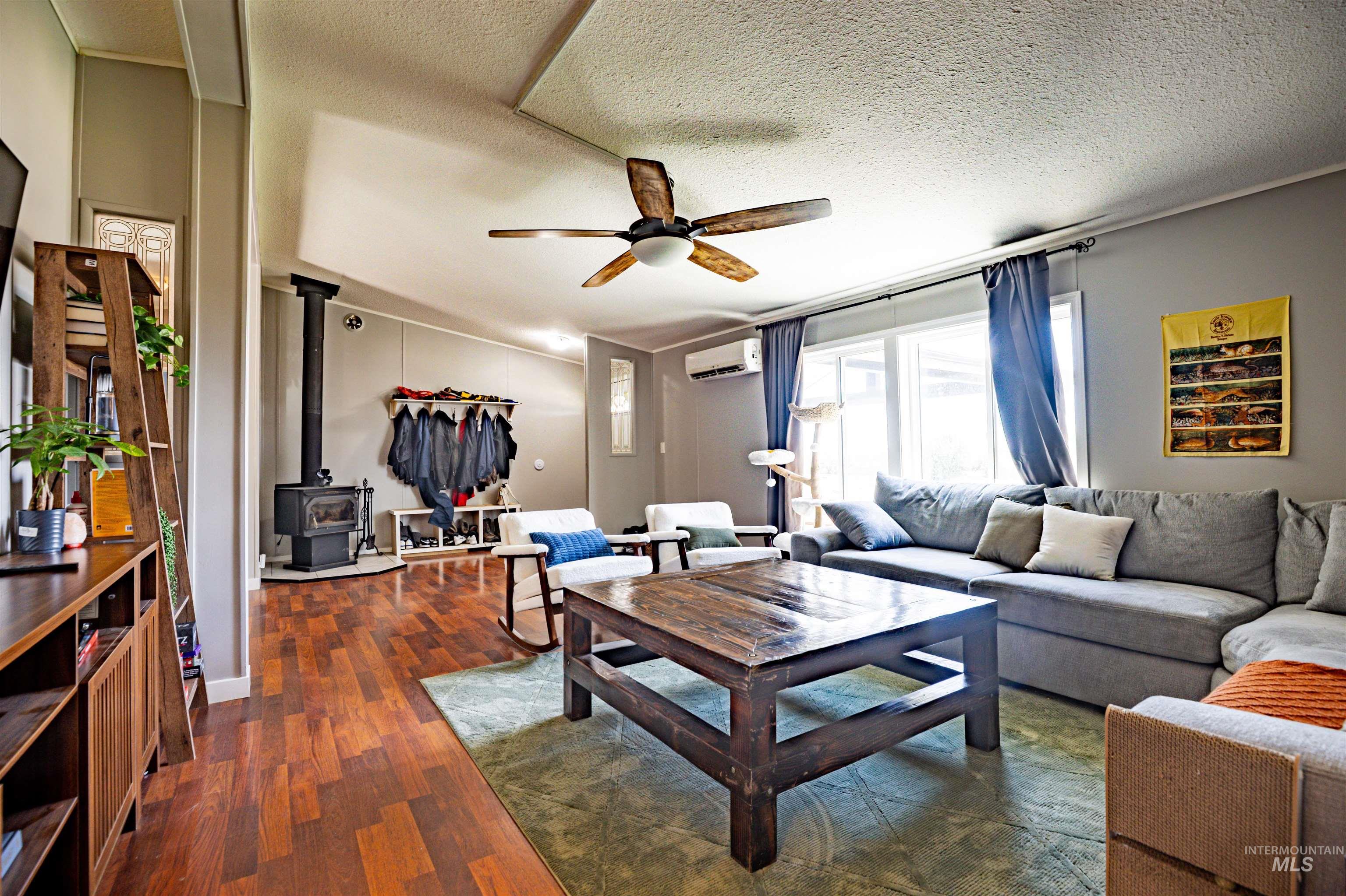 23904 Southview Lane Middleton, ID 83644 - Photo 23 of 29 Living space featuring wood-finish flooring, a ceiling fan, and a prominent wood-burning stove