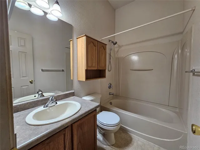 a bathroom with a granite countertop sink toilet mirror and shower