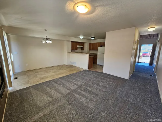 a view of a livingroom with furniture and an empty room