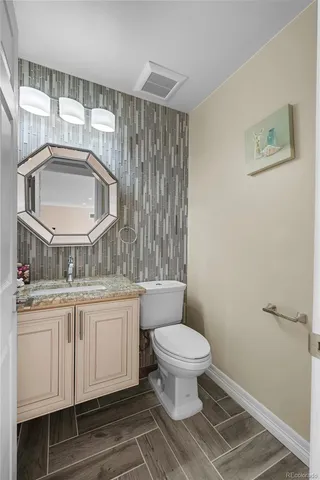 a bathroom with a toilet a sink and mirror