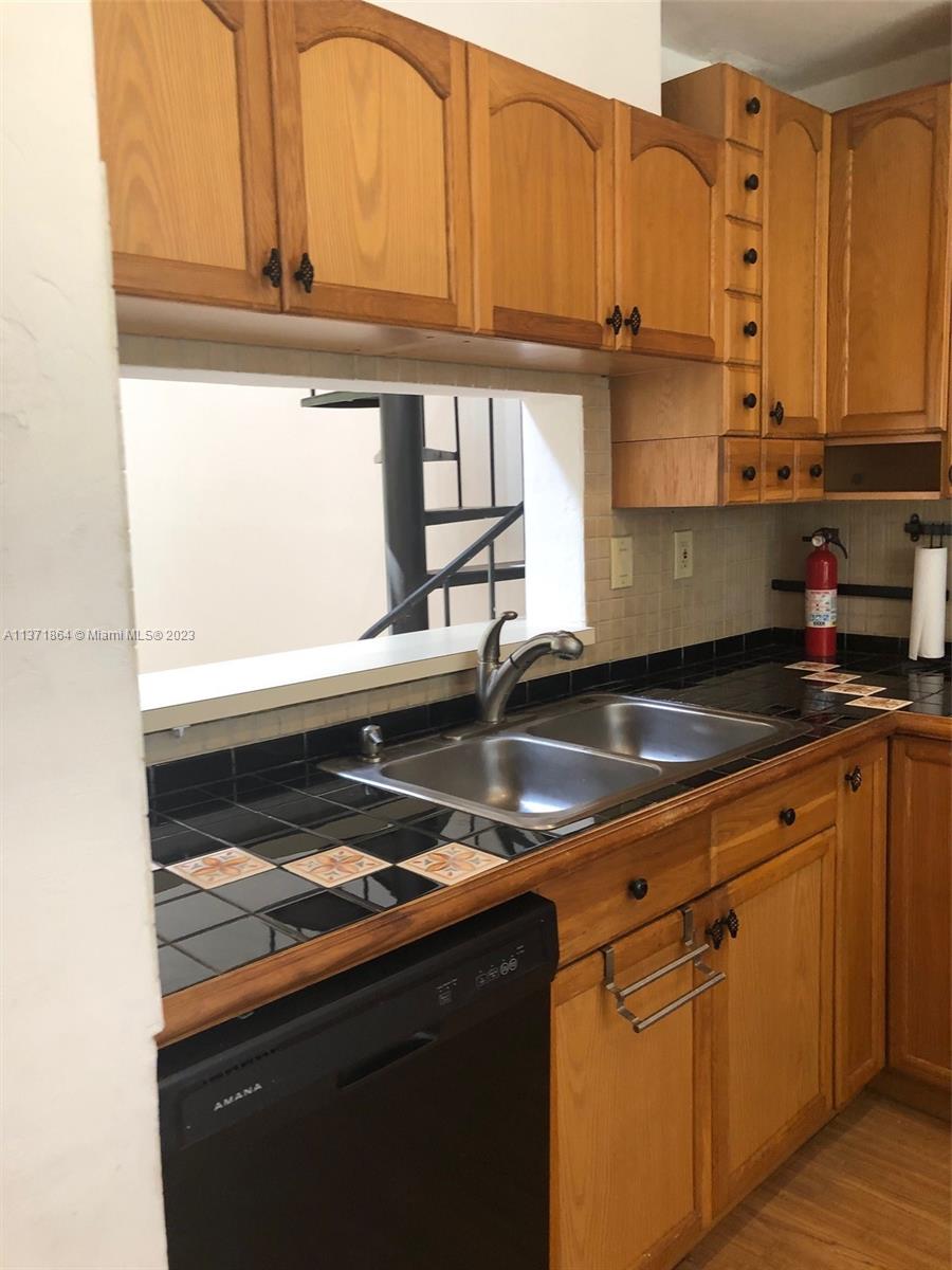 12902 Southwest 88th Terrace, Unit B201 Miami, FL 33186 - Photo 18 of 49 a kitchen with stainless steel appliances granite countertop a sink stove and cabinets
