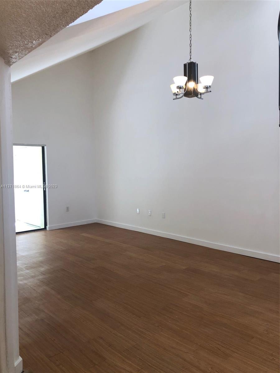 12902 Southwest 88th Terrace, Unit B201 Miami, FL 33186 - Photo 4 of 49 a view of empty room with wooden floor and window