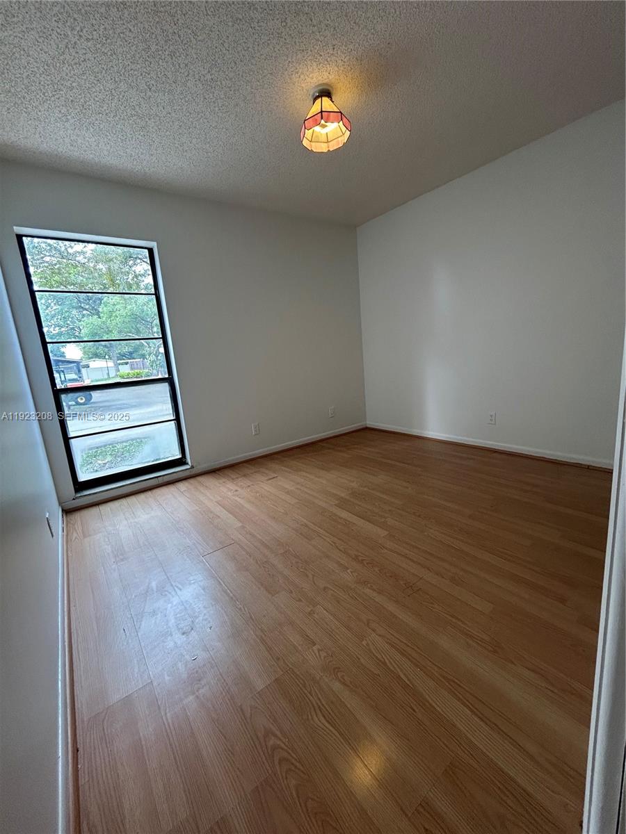 534 Briarwood Circle, Unit 148 Hollywood, FL 33024 - Photo 6 of 40 an empty room with wooden floor and windows