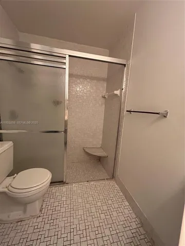 a white toilet sitting next to a bath tub and a shower