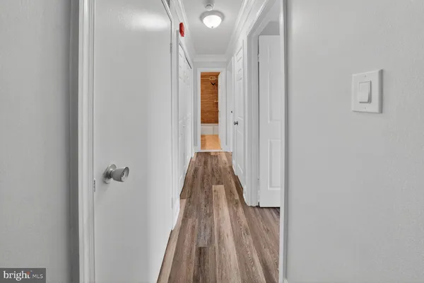 a view of a hallway with wooden floor and closet