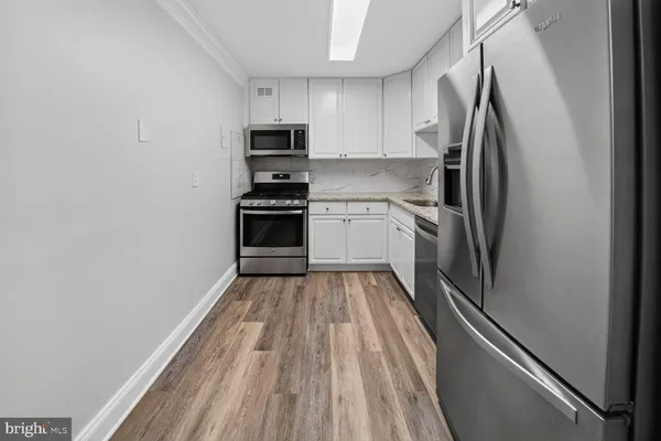 a kitchen with appliances a refrigerator and cabinets