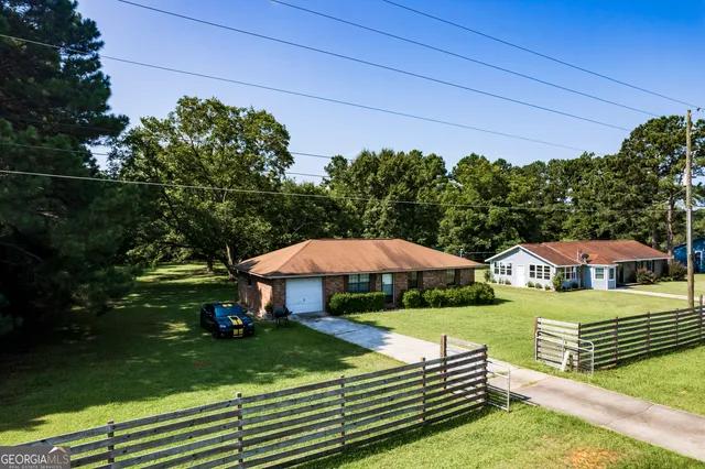 a view of a house with garden space and sitting area