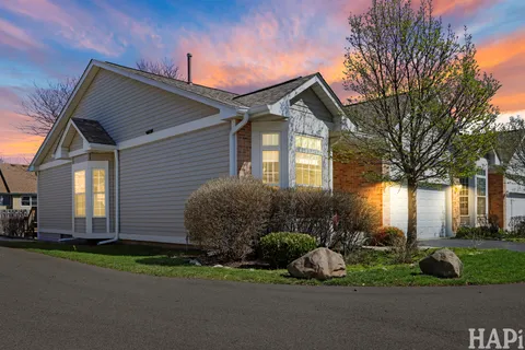 a front view of a house with a garden and plants