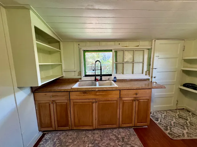 a kitchen with sink cabinets and wooden floor