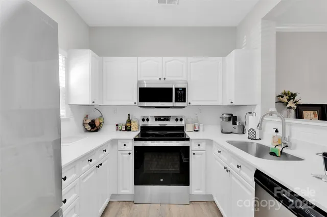a kitchen with white cabinets and appliances