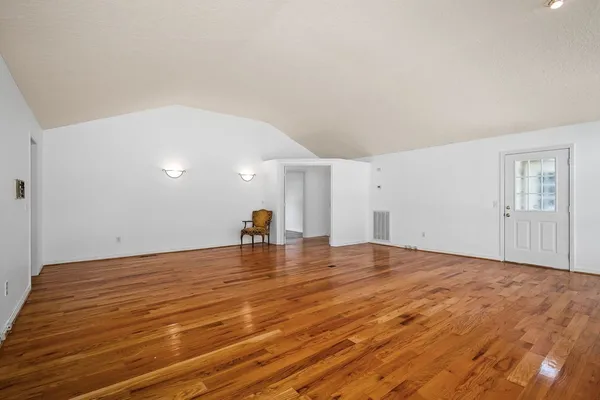 a view of empty room with wooden floor