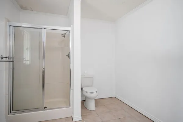 a bathroom with a granite countertop toilet and a shower