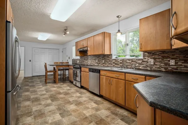 a kitchen with stainless steel appliances granite countertop a sink stove and cabinets