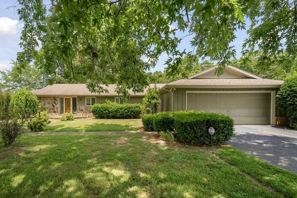a front view of a house with a yard and trees