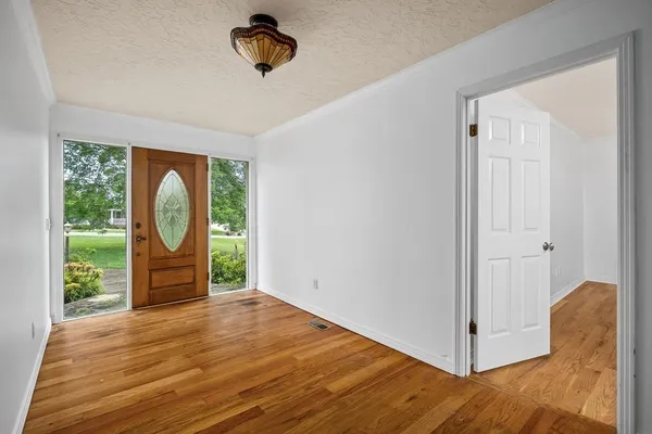 a view of a room with wooden floor entryway and windows